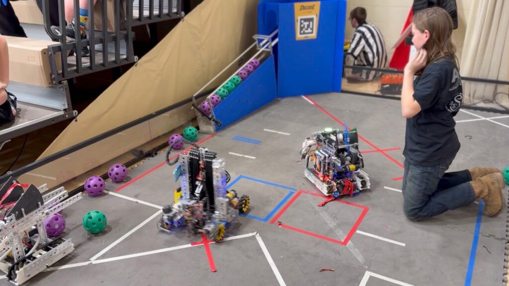 Photo of a student working with their built robot.
