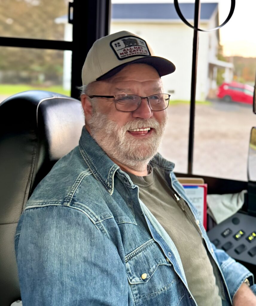 Bus driver Mr. Steve enjoys a laugh while waiting for the next run.